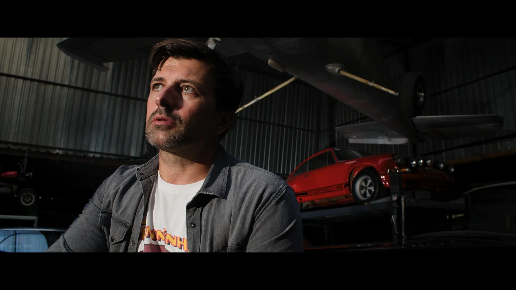 Portrait of a protagonist against a car — frame from the TCOS series
